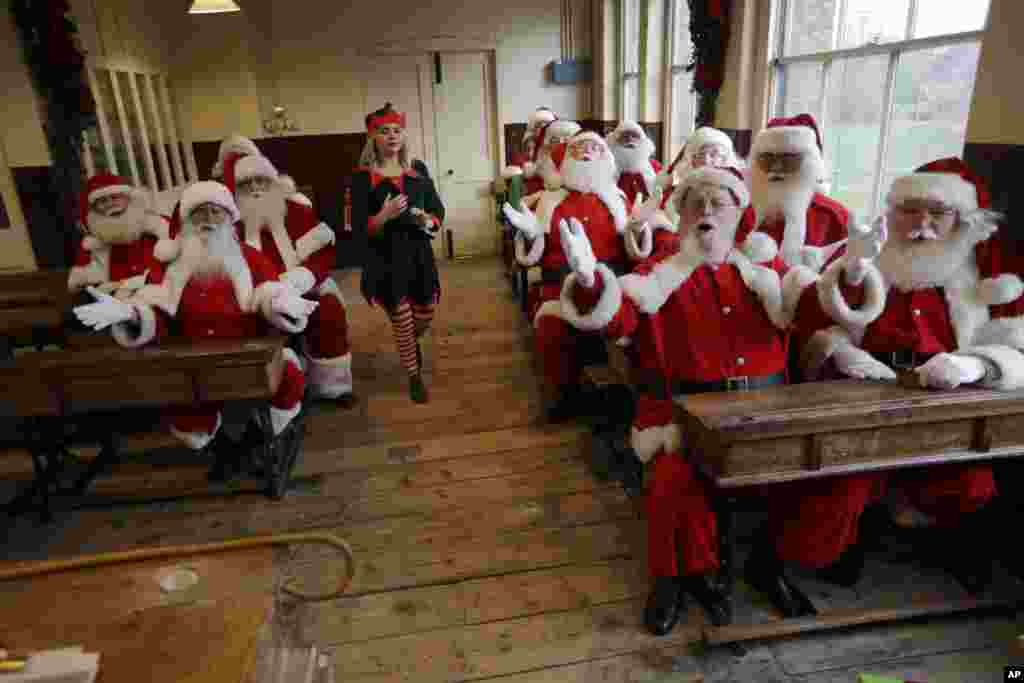 2017年11月16日，在倫敦東部的一所博物館外面，聖誕老人學校的媒體活動中，裝扮成聖誕老人的表演者在課堂上，讓記者照相。