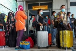 Buruh migran Indonesia tiba dari Malaysia di pelabuhan Bandar Sri Junjungan di Dumai, Riau pada 2 April 2020, setelah Indonesia menyatakan keadaan darurat pada 31 Maret akibat virus corona melonjak. (Foto: AFP/Iwan CKN)
