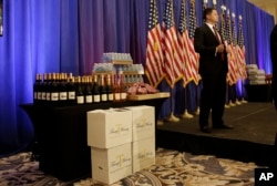 FILE - A secret service agent stands on the stage prior to a scheduled news conference by Republican presidential candidate Donald Trump in Jupiter, Fla., March 8, 2016. At left is a display of Trump-branded wine, water and steaks.