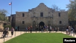 Visitors walk at the entrance to the Alamo, the most-visited tourist site in the state, in San Antonio, Texas, March 2, 2015. 