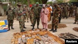 Officials stand near ammunition seized from suspected members of Hezbollah after raid of building in Kano, Nigeria, May 30, 2012