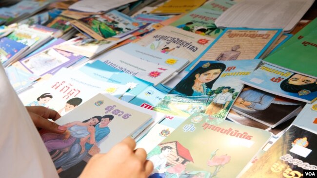 A high school student scans for Khmer novels in a book store, Phnom Penh, Cambodia, March 11, 2017. (Khan Sokummono/VOA Khmer)