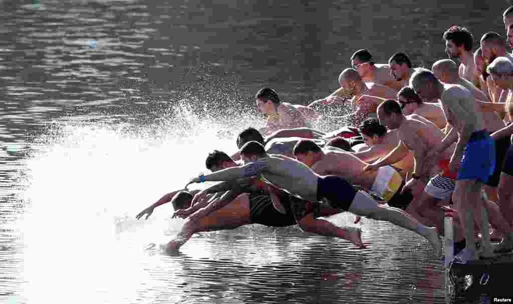 Men jump into a lake in attempt to catch a wooden cross during a celebration of Epiphany Day in Sofia, Bulgaria.