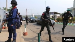 Security personnel take positions as police officers run along the convoy of Nigeria's President Goodluck Jonathan after a People's Democratic Party (PDP) National Executive Council meeting in Abuja, Jan. 16, 2014.