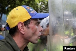 FILE - Venezuelan opposition leader Henrique Capriles talks to riot police during a rally to demand a referendum to remove President Nicolas Maduro in Caracas, Venezuela, June 7, 2016.
