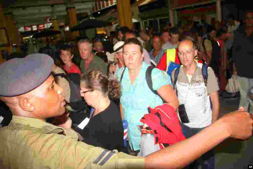 Afisa wa polisi wa Kenya akishika zamu wakati abiria wa ndege ya Air France wakipiti kituo cha ukaguzi kwenye uwanja wa ndege wa Moi mjini Mombasa Kenya, Jumapili, Dec. 20, 2015