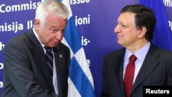 European Commission President Jose Manuel Barroso, right, welcomes Greek Prime Minister Panagiotis Pikrammenos at the European Commission headquarters in Brussels, May 23, 2012. 