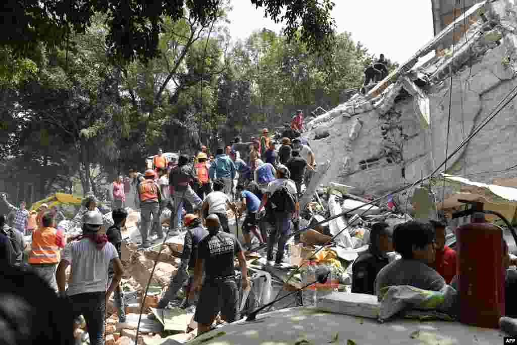 People remove debris of a collapsed building looking for possible victims after a quake rattled Mexico City. The U.S. Geological Survey put the quake&#39;s magnitude at 7.1 while Mexico&#39;s Seismological Institute said it measured 6.8 on its scale. The institute said the quake&#39;s epicenter was seven kilometers west of Chiautla de Tapia, in the neighboring state of Puebla.