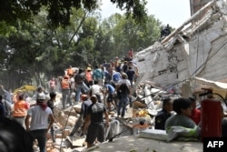 مردم در حال کمک به ساختمان های تخریب شده در مکزیکو سیتی هستند.