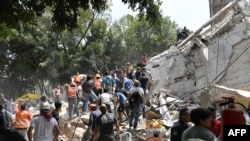 People remove debris of a collapsed building looking for possible victims after a quake rattled Mexico City, Sept. 19, 2017.
