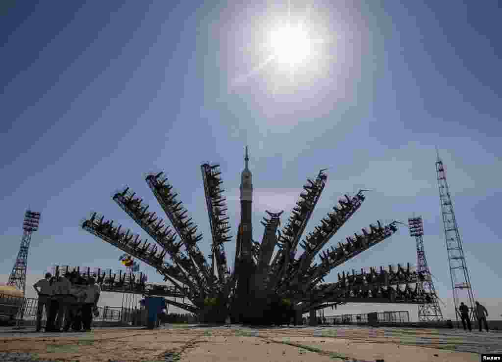 Service towers move towards the Soyuz TMA-13M spacecraft set on its launch pad at Baikonur cosmodrome in Kazakhstan.