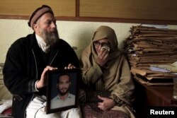 Muhammad Azeem, left, and Sajida Parveen, the parents of Ehsan Azeem, who was sentenced to death by a military court, react while holding their son's picture in Rawalpindi, Jan. 23, 2015. Military documents show Azeem was accused of attacking a military camp, yet he was sentenced for sedition. When his parents were finally allowed to visit him in prison, Azeem told them he was tortured and had never appeared in court or spoken to a lawyer.