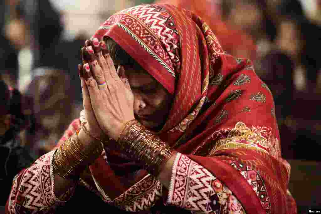 A woman prays during a Christmas service at the Sacred Heart Cathedral in Lahore, Pakistan, Dec. 25, 2018.