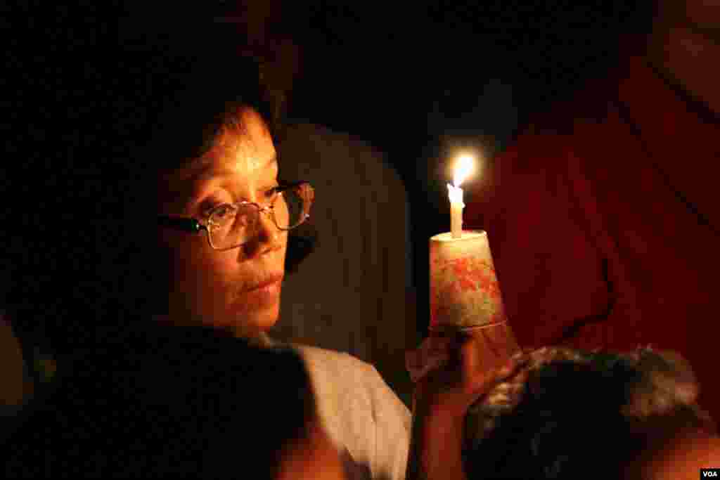 Lay Ra, 52, from Silver Spring takes part in a candle vigil during a memorial service for Khmer Rouge victims at the Wat Buddhikaram Cambodian Buddhist temple in Silver Spring, Maryland, to mark the 40th anniversary of the takeover of the Khmer Rouge, on Friday, April 17, 2015. She tells VOA Khmer that she was forced out of Battambang city on the day the Khmer Rouge took over Cambodia 40 years ago. Her family came to the US as refugees in 1983. (Sophat Soeung/VOA Khmer)