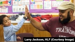 Holistic Life Foundation co-founder Ali Smith (brother of Atman Smith) gives a “high five” to a student in the Holistic Me After School Program.
