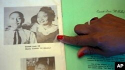 Deborah Watts of Minneapolis, points out a widely seen 1950s photograph of her cousin Emmett Till and his mother Mamie Till Mobley, during a visit to Jackson, Miss., Thursday, Aug. 27, 2015 to mark the 60th anniversary of the slaying of Till, 14, in Mississippi. A law that calls for investigating unsoved civil rights era murders was named for Till. (AP Photo/Rogelio V. Solis)