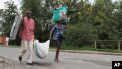 Burundians carry their belongings in Bujumbura, Burundi, Nov. 7, 2015. Carrying their prized possessions, scores of people have fled Burundi’s capital before a security crackdown.