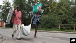 People carry their belongings in Bujumbura, Burundi, Nov. 7, 2015. 