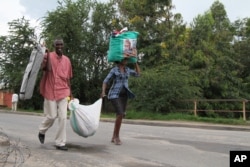 FILE - Burundians carry their belongings Nov. 7, 2015, in Bujumbura, Burundi.