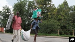 People carry their belongings in Bujumbura, Burundi, Nov. 7, 2015. 