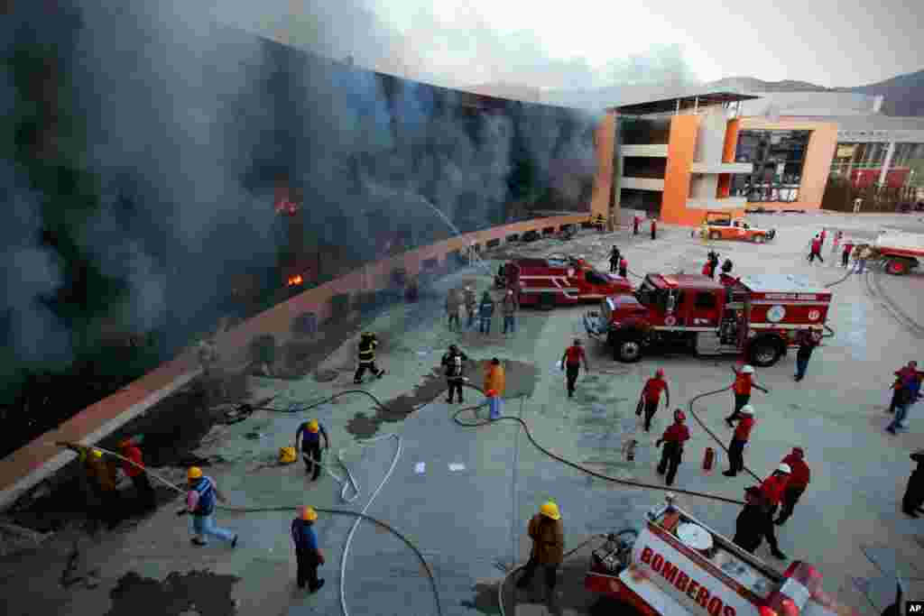 Pemadam kebakaran berusaha memadamkan kobaran api dalam protes mahasiswa di kota&nbsp;Chilpancingo, Meksiko. 