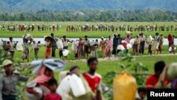 စပါးကွင်းတွေဖြတ်ပြီး မြန်မာပြည်ကနေ ဘင်္ဂလားဒေ့ရှ်ဘက်ကူးသွားကြတဲ့ ရိုဟင်ဂျာဒုက္ခသည်များ။ (အောက်တိုဘာ ၁၉၊ ၂၀၁၇) 