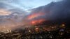 Des flammes sont attisées par des vents violents après qu'un feu de brousse se soit déclaré sur les pentes de la Table Mountain au Cap, en Afrique du Sud, le 19 avril 2021.