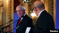 U.S. Secretary of States Rex Tillerson speaks with French Foreign Affairs Minister Jean-Yves Le Drian as they attend the Lebanon international Support Group meeting in Paris, France, Dec. 8, 2017. 