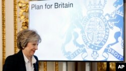 FILE - Britain's Prime Minister Theresa May smiles as she arrives to deliver a speech on leaving the European Union at Lancaster House in London, Jan. 17, 2017. 