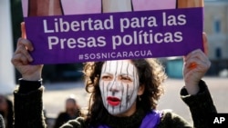 Varios grupos civiles han denunciado que el gobierno de Nicaragua les reprimen y viola sus derechos. Una protestante sostiene un cartel durante una marcha en de ciudadanos nicaragüenses en España. Foto AP.