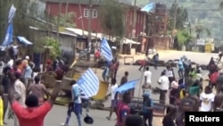 FILE - A still image taken from a video shot on Oct. 1, 2017, shows protesters waving Ambazonian flags in front of a road block in the English-speaking city of Bamenda, Cameroon. 