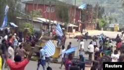 FILE - A still image taken from a video shot on Oct. 1, 2017, shows protesters waving Ambazonian flags in front of a road block in the English-speaking city of Bamenda, Cameroon.
