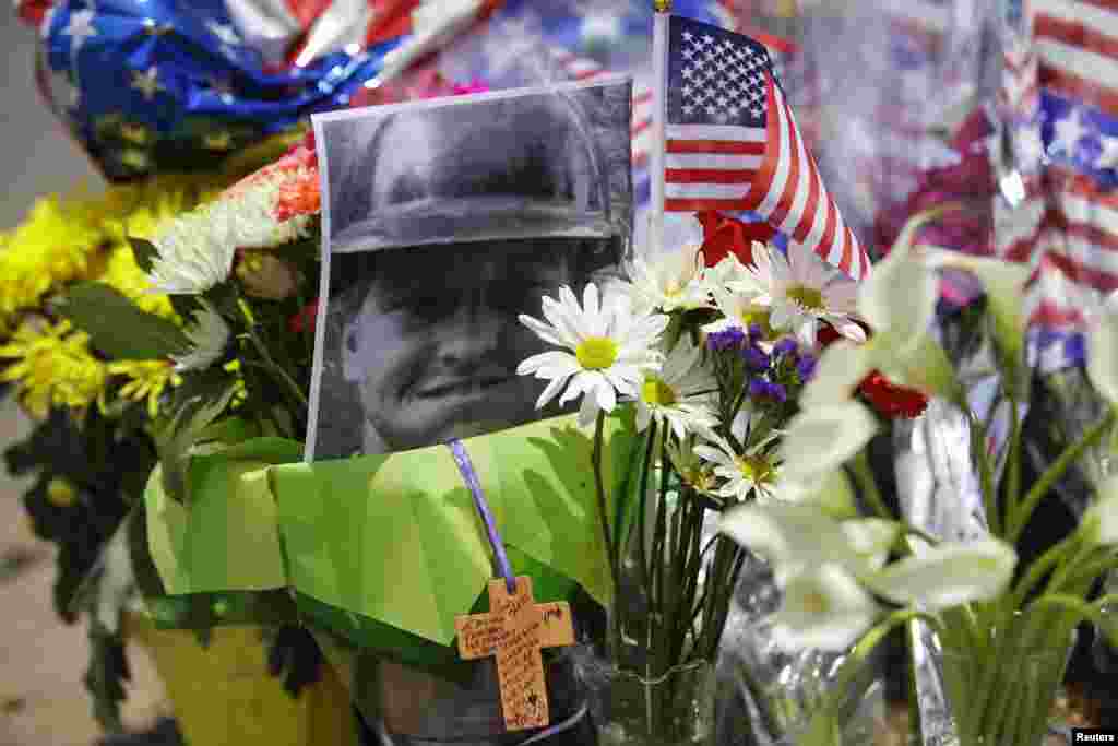 A photo of Wade Parker, one of 19 firefighters who died battling a fast-moving wildfire, is displayed at a makeshift memorial in Prescott, Arizone, July 1, 2013.