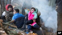 Emigrantët nga Lindja e Mesme të bllokuar përgjatë kufirit Bjellorusi - Poloni, në pyjet pranë qytetit Grodno Grodno, të Bjellorusisë ((9 nëntor 2021, Leonid Shcheglov/BelTA via AP))