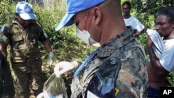 UN peacekeepers from Guatemala take a sample of excrement next to the Nepali UN base in Mirebalais, 27 Oct 2010