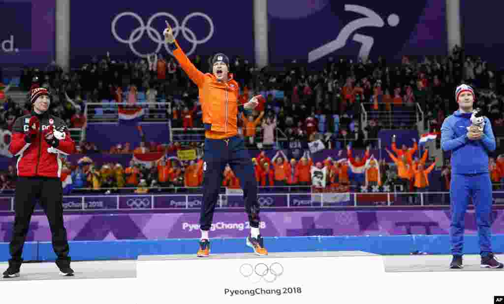 Gold medallist and new Olympic record holder Sven Kramer of The Netherlands, center, celebrates with silver medallist Ted-Jan Bloemen of Canada, left, and bronze medallist Norway's Sverre Lunde Pedersen, right, after the men's 5,000 meters race.