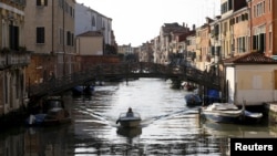 A bridge that once separated the Venice ghetto (L) from Catholic Venice (R) is seen as a boat passes northern Italy, March 22, 2016. 
