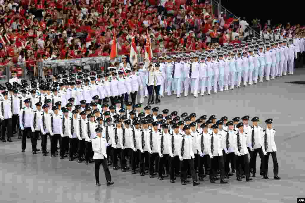 Contingents march inside the national stadium during National Day celebrations in Singapore.&nbsp;