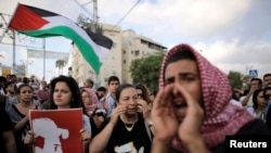 Israeli Arabs protest last week's abduction and killing of Palestinian teenager Mohammed Abu Khdeir in the northern city of Acre, July 7, 2014.