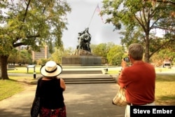 Two visitors from Canada take photos of the Iwo Jima Statue