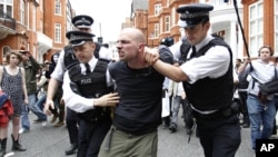 Policías británicos arrestan a un manifestante a favor de Julian Assange, frente a la embajada de Ecuador en Londres. En minutos, Ecuador anunciará su decisión sobre la concesión de asilo para el fundador de WikiLeaks.