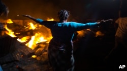 A Haitian merchant reacts as she watches flames engulf her belongings at a market Petion-Ville suburb of Port-au-Prince, Haiti, Nov. 20, 2016.