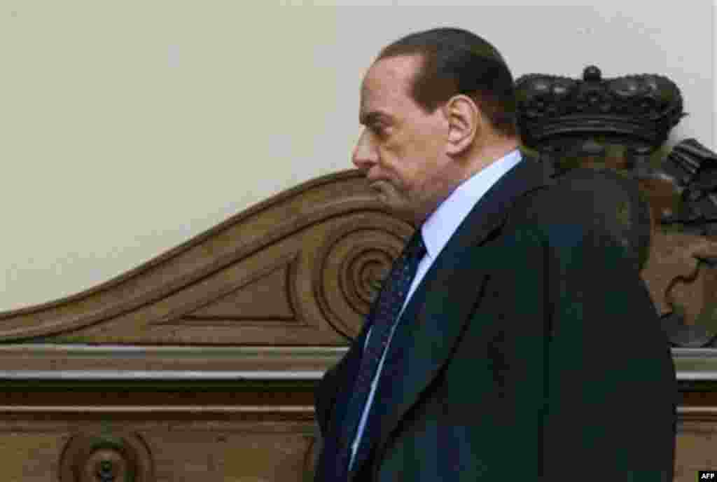 Italian Premier Silvio Berlusconi walks in the courtyard as he leaves his private residence, in Rome, Saturday, Nov. 12, 2011. Berlusconi is expected to resign Saturday after the parliament's lower chamber passes European-demanded reforms aimed to to ste