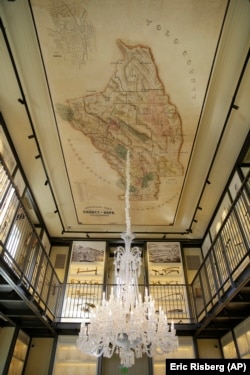 In this photo taken Wednesday, June 5, 2019, a 48-light Baccarat crystal chandelier and a reproduction of an 1895 map of Napa County on canvas hang from the ceiling of the 1881 Napa in Oakville, Calif.