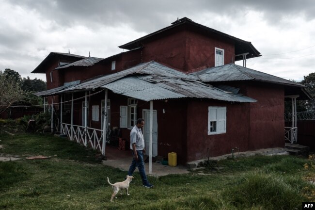 FILE - Berhanu Mengistu walks his dog in front of his family house which has been protected as a historic house by the tourism bureau in Addis Ababa, Nov. 29, 2018.