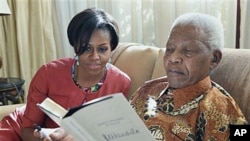 US first lady Michelle Obama (L) with former South African President Nelson Mandela, at this home, in Houghton, South Africa, June 21, 2011