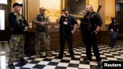 FILE - Michael John Null and Willam Grant Null (R) who were charged October 8, 2020 for their involvement in a plot to kidnap the Michigan governor, attack the state capitol building and incite violence, stand near the doors to the chamber in the capitol 