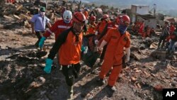 폭우와 쓰나미가 강타한 인도네시아 술라웨시섬에서 구조대원들이 8일 희생자 시신을 옮기고 있다. 