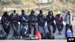 Para migran menunggu bus yang akan membawa mereka meninggalkan kamp "Junggle" di Calais menuju tempat baru, 28 Oktober 2016 (Foto: dok). 