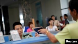 중국 지린성 훈춘의 북한 접경 출입국사무소에서 직원이 입국자 여권을 확인하고 있다. (자료사진)